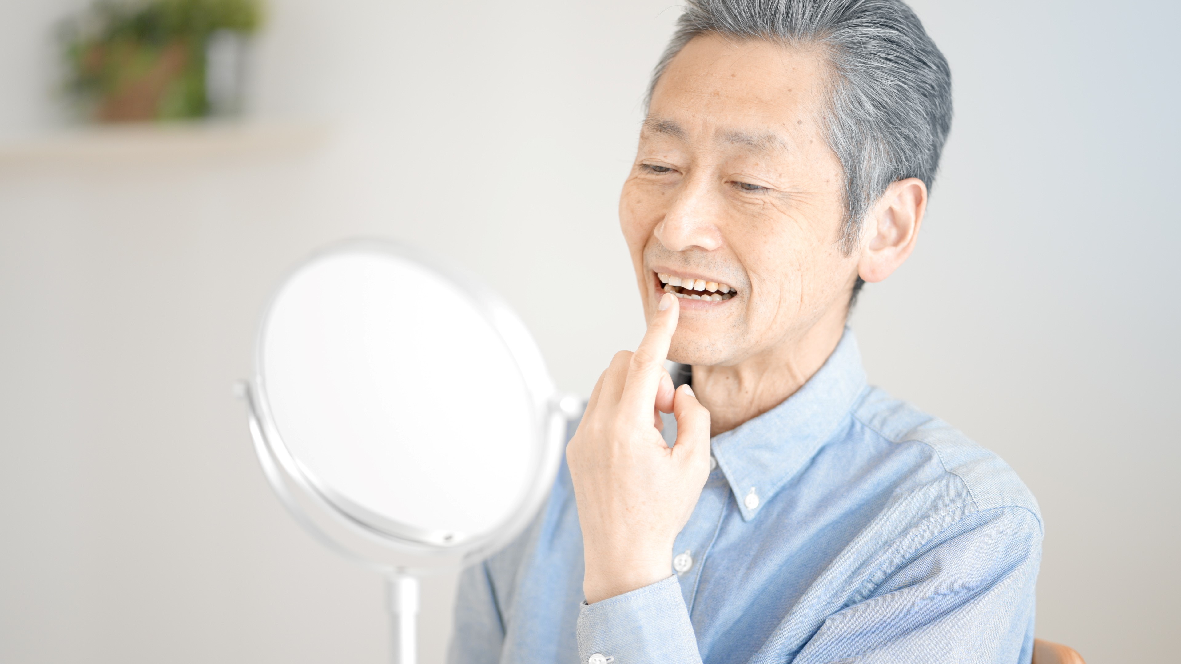 鏡で歯を確認する男性