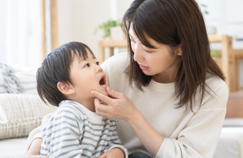 子供の歯をチェックする母親